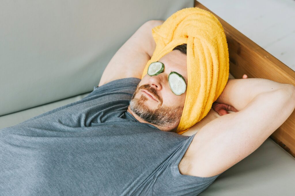 Man relaxing back after having acupuncture by Emma Rose-Roberts, with cucumber on his eyes.